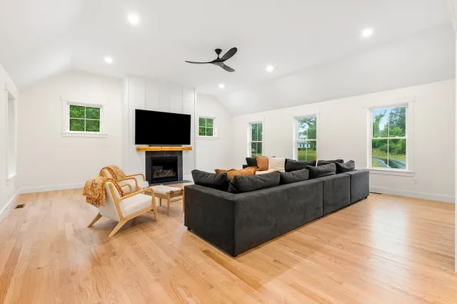 a living room with furniture a fireplace and a flat screen tv