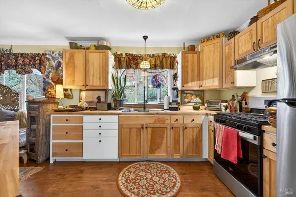 a kitchen with stainless steel appliances granite countertop a stove a sink and a refrigerator