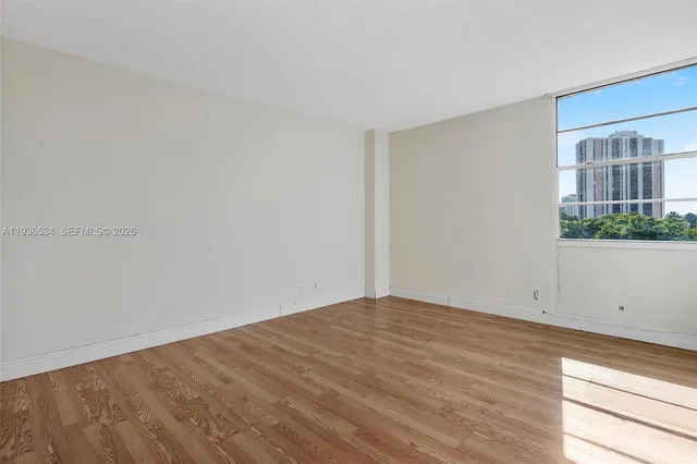 a view of empty room with window and wooden floor