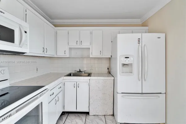 a kitchen with cabinets and white appliances