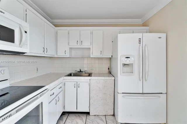 a kitchen with cabinets and white appliances