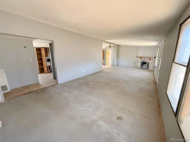 an empty room with a mirror and windows