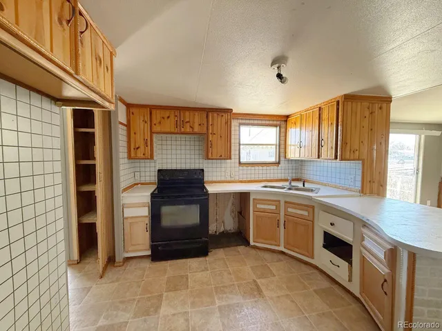 a kitchen with a stove sink and cabinets
