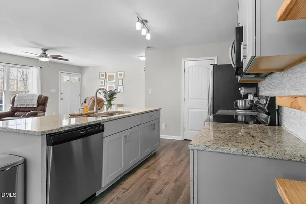 a kitchen with granite countertop a sink a counter top space and cabinets