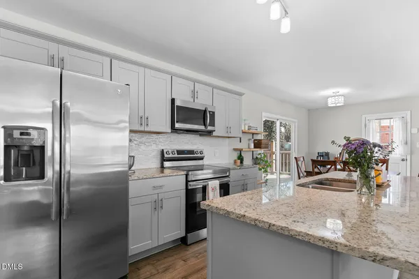 a kitchen with a refrigerator a microwave a sink and cabinets