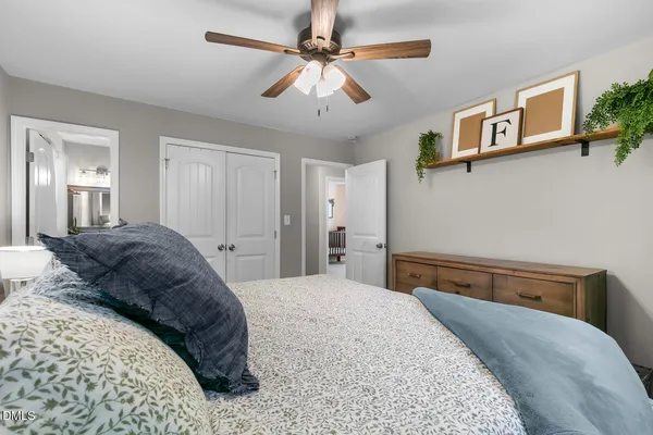 a bedroom with a large bed and a chandelier