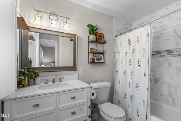a bathroom with a granite countertop sink a toilet and a mirror