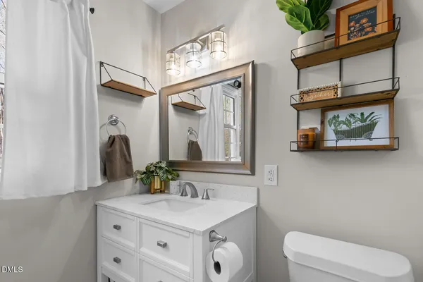 a bathroom with a toilet a sink and a mirror