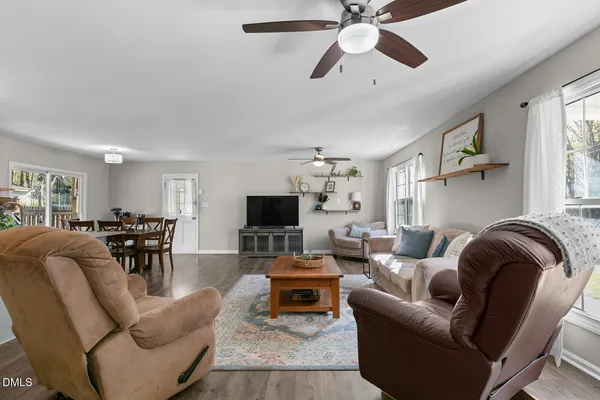 a living room with furniture and a flat screen tv with wooden floor