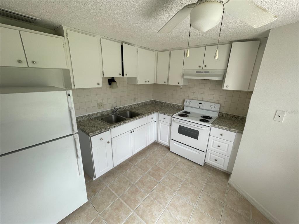 5311 Avery Road New Port Richey, FL 34652 - Photo 19 of 34 a kitchen with granite countertop white cabinets and white appliances