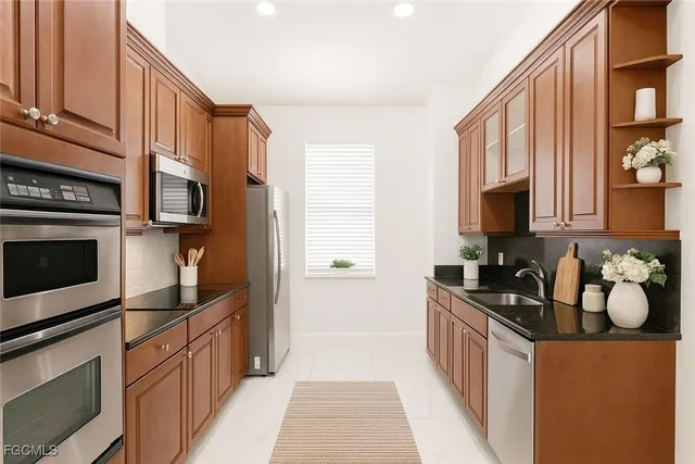 a kitchen with stainless steel appliances granite countertop a stove a sink and a microwave
