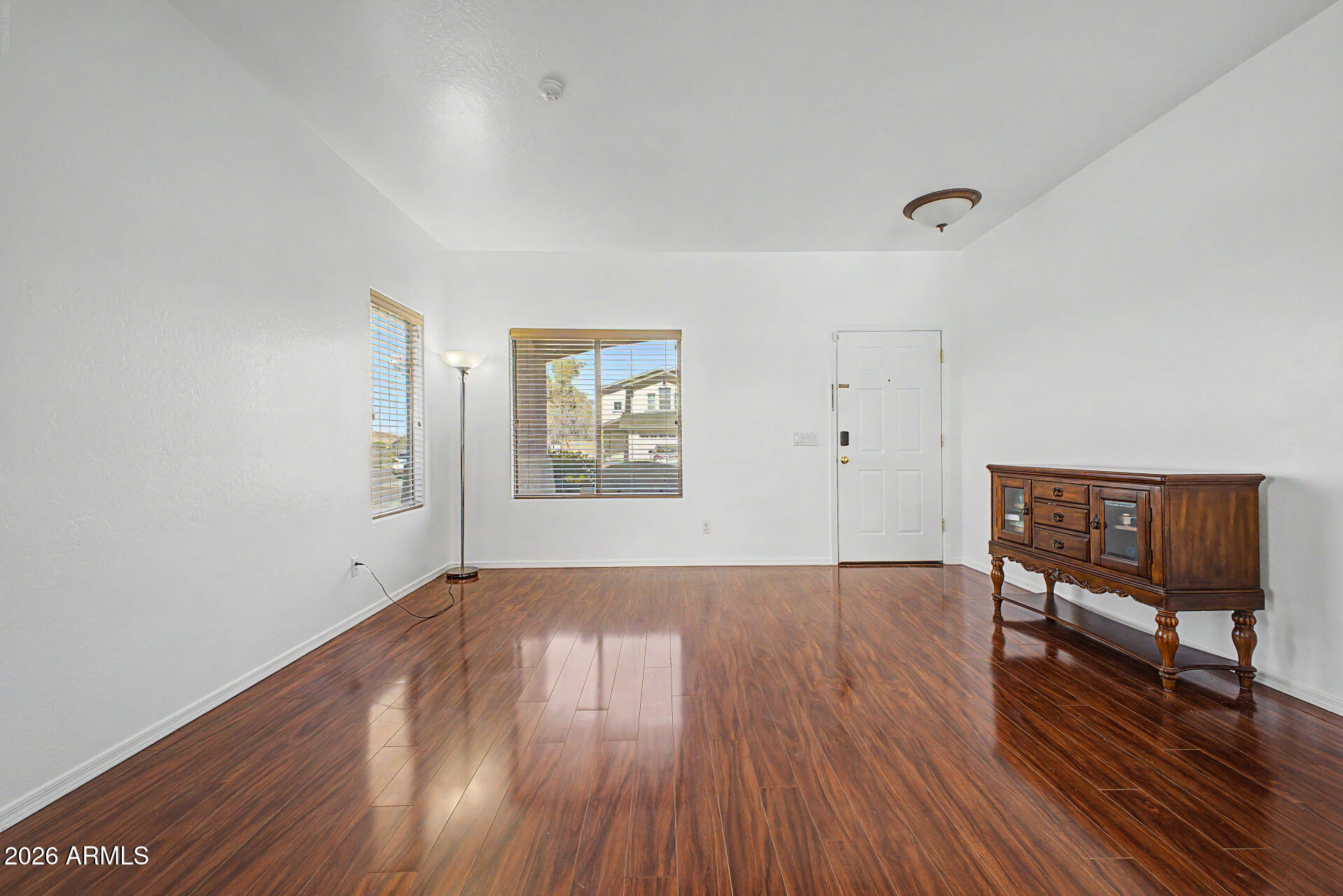 7206 South 12th Way Phoenix, AZ 85042 - Photo 6 of 34 an empty room with wooden floor and windows