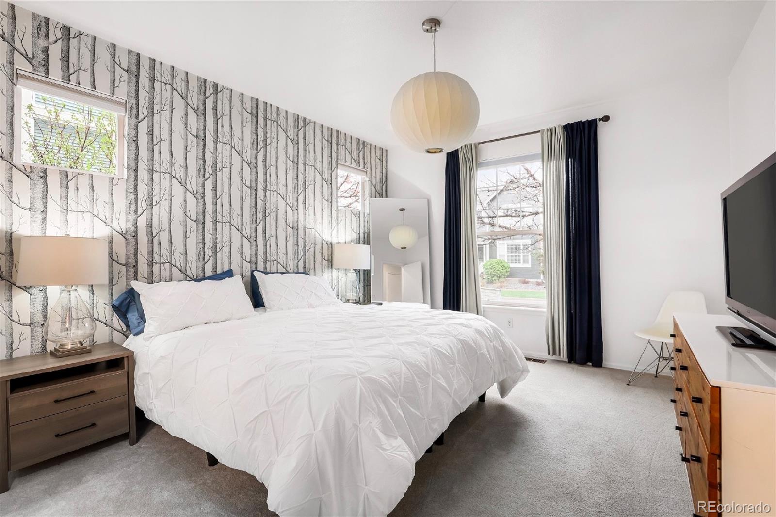 1947 King Street Denver, CO 80204 - Photo 12 of 40 a bedroom with a bed and a flat tv screen on dresser