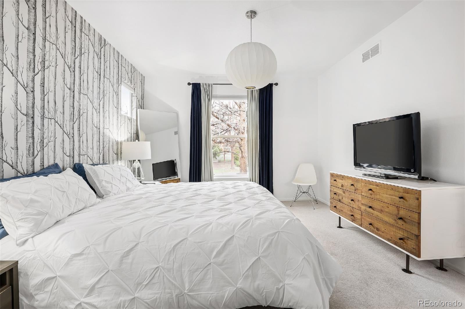 1947 King Street Denver, CO 80204 - Photo 13 of 40 a bedroom with a bed and a flat tv screen on dresser
