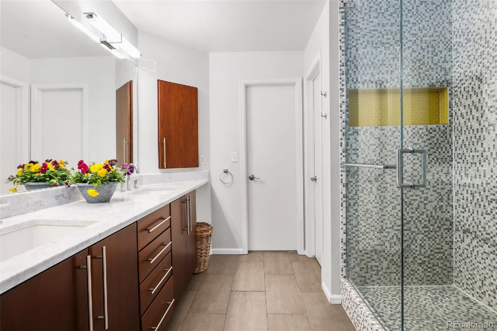 1947 King Street Denver, CO 80204 - Photo 14 of 40 a bathroom with a granite countertop sink a mirror and a shower