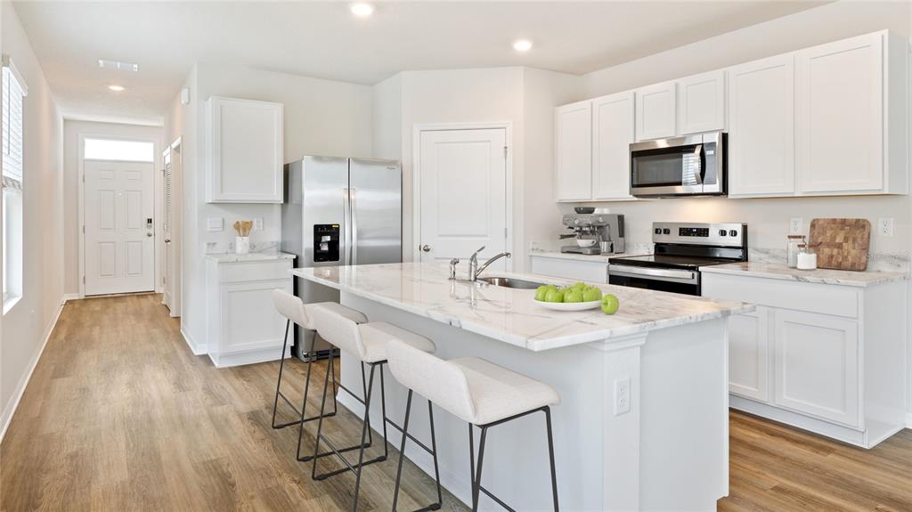 8808 Clear View Street Parrish, FL 34219 - Photo 3 of 16 a kitchen with stainless steel appliances a sink a stove a refrigerator cabinets and a counter top space