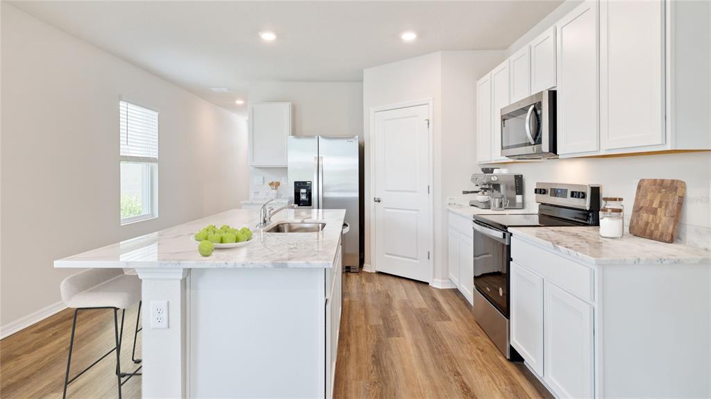 8808 Clear View Street Parrish, FL 34219 - Photo 5 of 16 a kitchen with a sink a stove cabinets and wooden floor