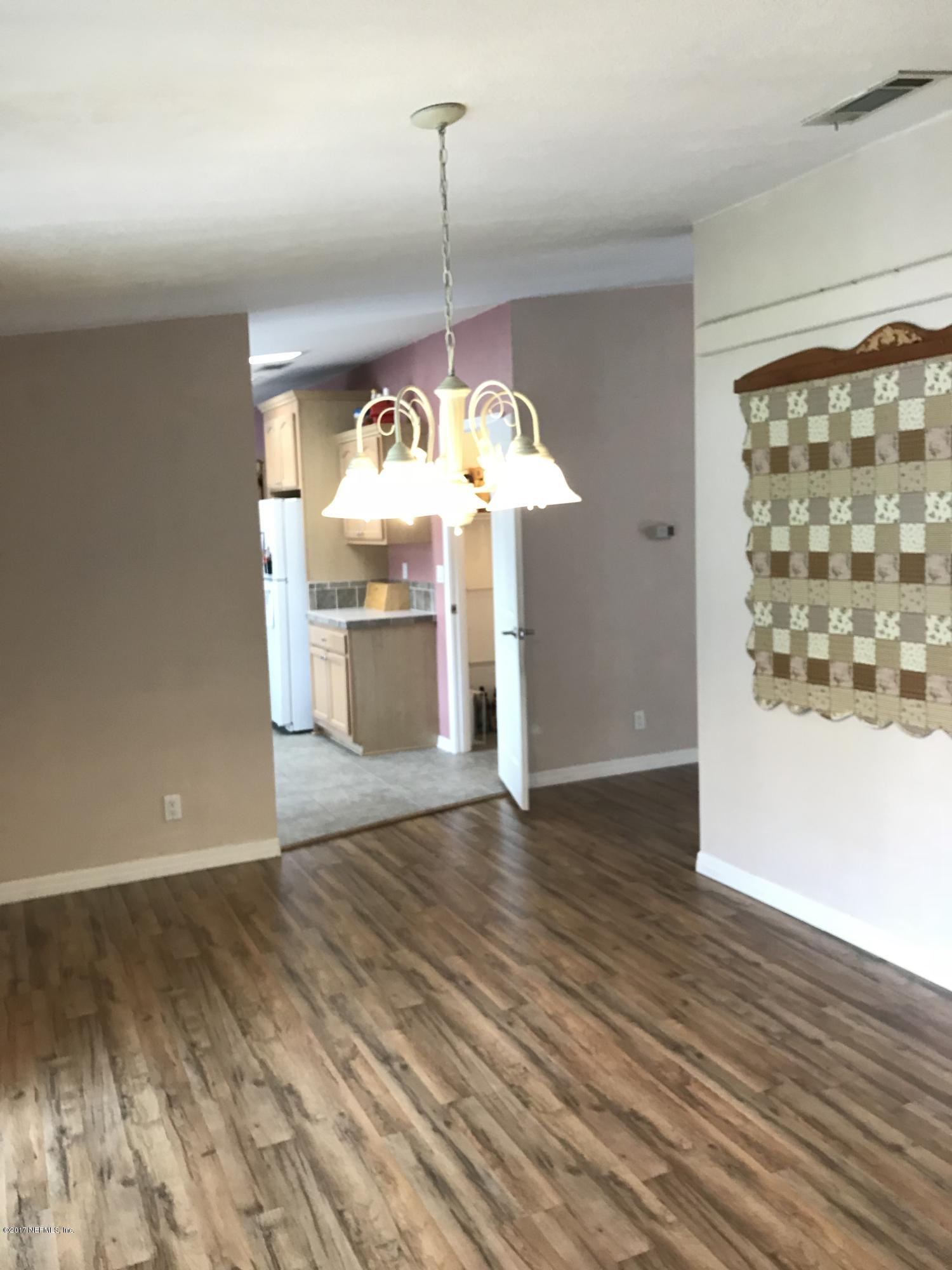 16113 Sawpit Road Jacksonville, FL 32226 - Photo 18 of 18 a view of a room with wooden floor stove and a kitchen view