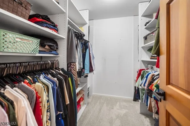 a view of walk in closet with clothes and shoes