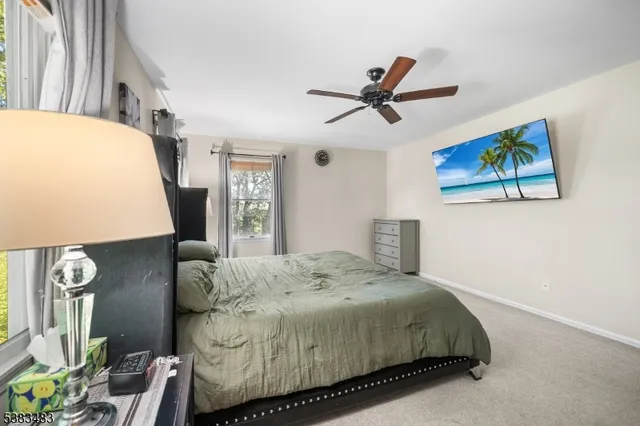 a bedroom with a bed a window and painting on the wall