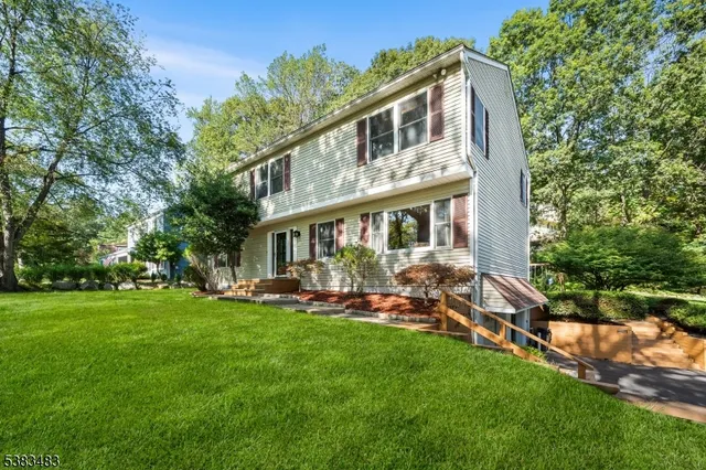 a front view of a house with a garden and sitting area