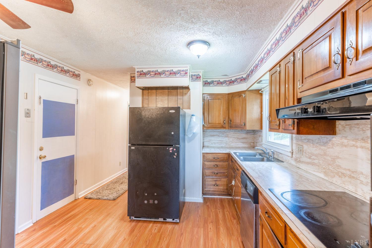 1040 Brookhill Road Forest, VA 24551 - Photo 7 of 27 a kitchen with stainless steel appliances granite countertop a refrigerator a stove and a sink with wooden floors