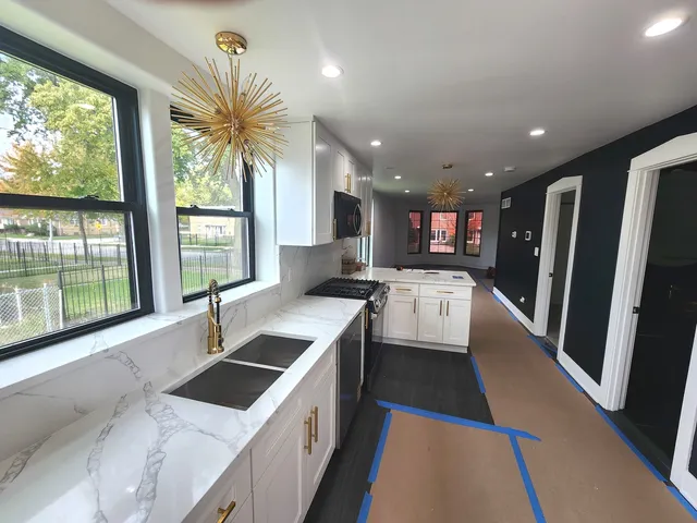 a kitchen with stainless steel appliances granite countertop a sink a stove and a refrigerator