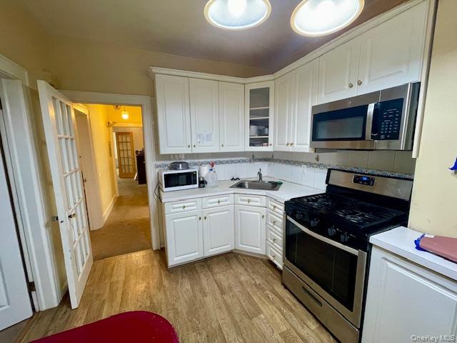 50-44 39th Street Queens, NY 11104 - Photo 4 of 15 a kitchen with stainless steel appliances granite countertop a stove a sink and a microwave