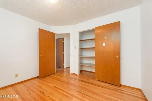 a view of empty room with wooden floor and closet
