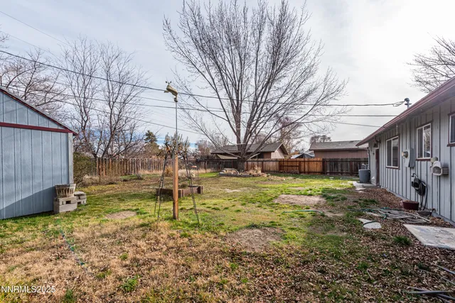 a backyard of house with a slide and large trees