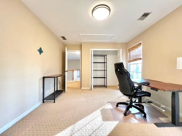 a view of a workspace with furniture and a window