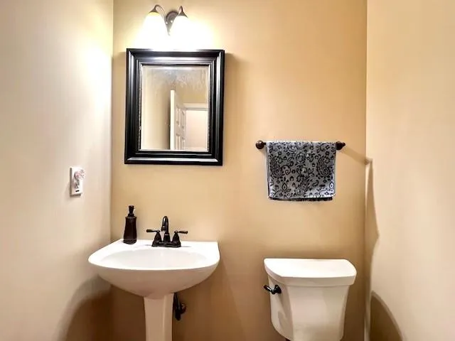 a bathroom with a toilet sink and mirror