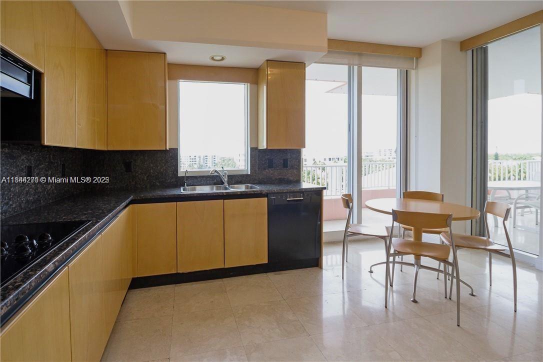 785 Crandon Boulevard, Unit 506 Key Biscayne, FL 33149 - Photo 12 of 58 a kitchen with granite countertop a stove a sink and a microwave