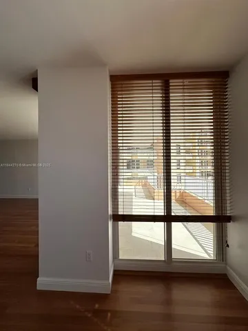 a view of empty room with wooden floor and entryway