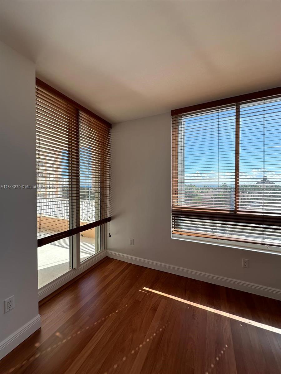 785 Crandon Boulevard, Unit 506 Key Biscayne, FL 33149 - Photo 27 of 58 an empty room with wooden floor and windows