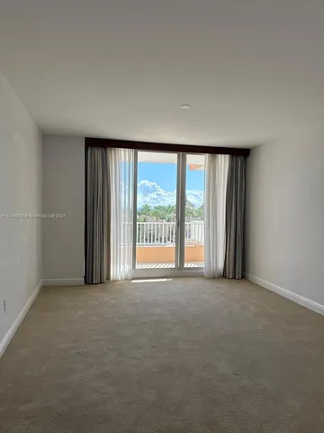 an empty room with wooden floor and entrance