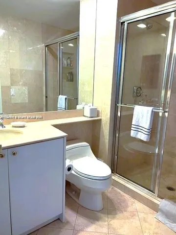 a bathroom with a granite countertop toilet sink and shower