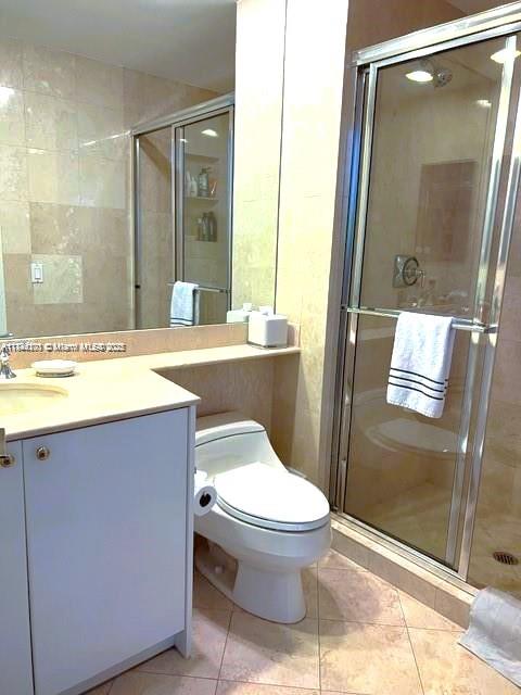 785 Crandon Boulevard, Unit 506 Key Biscayne, FL 33149 - Photo 4 of 58 a bathroom with a granite countertop toilet sink and shower