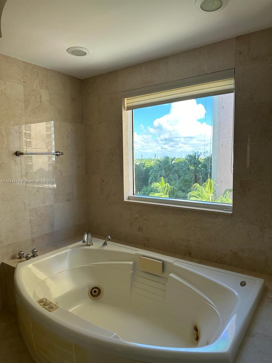 785 Crandon Boulevard, Unit 506 Key Biscayne, FL 33149 - Photo 47 of 58 a bathroom with bathtub and window