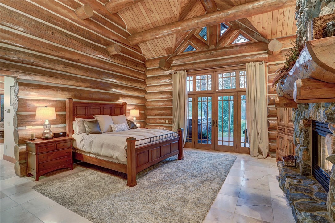 1381 Johnson Road Silverthorne, CO 80498 - Photo 15 of 35 Past the office you will find the main floor mast bedroom. This bedroom features vaulted ceilings, a floor to ceiling fireplace, doors to the outside deck and hot tub, and a grand master ensuite bathroom.