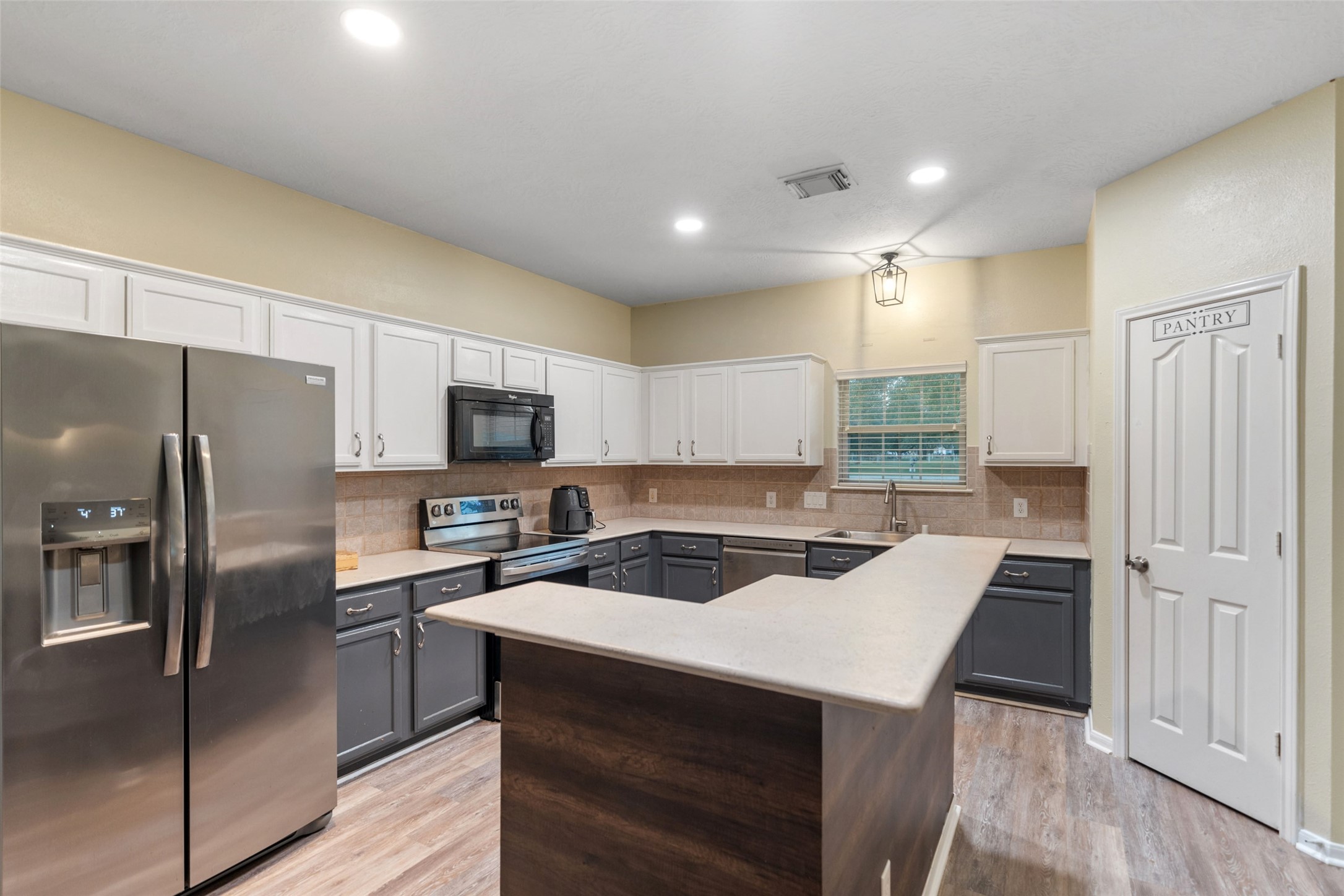118 Pin Oak Lane Hempstead, TX 77445 - Photo 12 of 29 Functional kitchen with ample cabinetry, stainless steel dishwasher, and window over the sink for natural light.