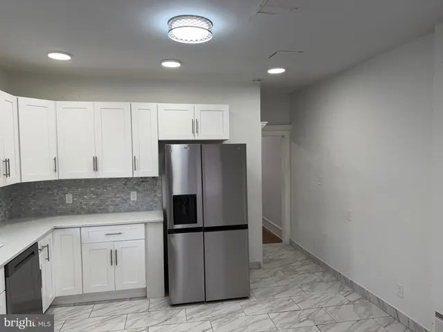 a kitchen with white cabinets and stainless steel appliances