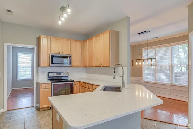 a kitchen with stainless steel appliances granite countertop a sink a stove and a refrigerator