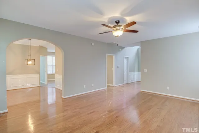a view of an empty room with window and wooden floor