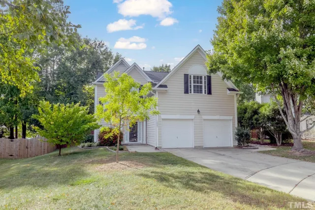 a view of a house with a yard and tree