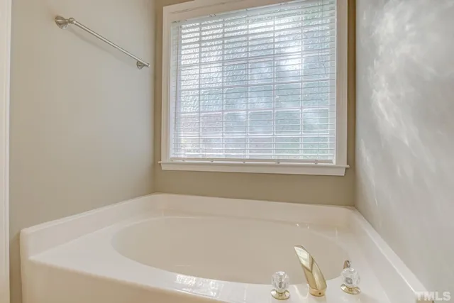 a white bath tub sitting in a bathroom next to a window