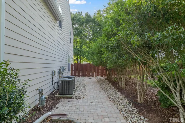 a view of a backyard with chair and potted plants