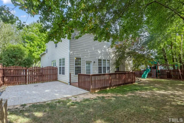 a view of a house with a yard and a large tree