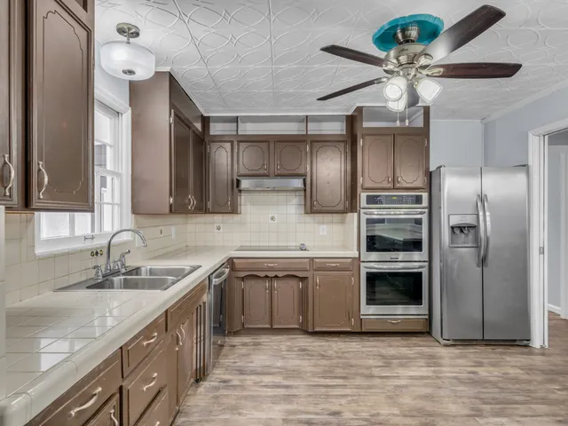 a kitchen with stainless steel appliances granite countertop a sink and a refrigerator