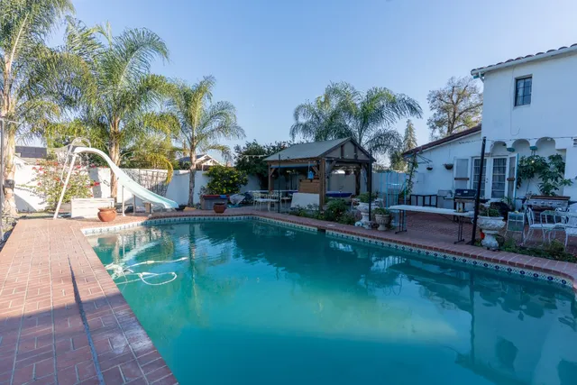 a swimming pool view with a seating space